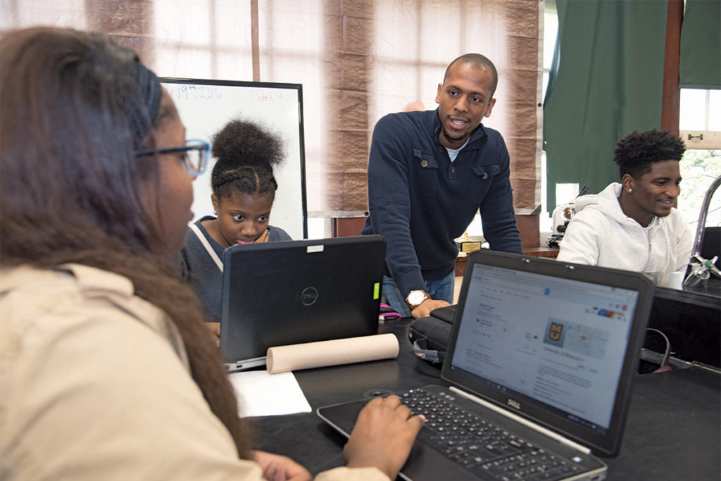 Mentor Jeffrey Gamble (center), a doctoral candidate in biomedical engineering, interacts with students at Soldan International Studies High School. YSP Continuing Mentor volunteers meet regularly with students during all four years of high school. 