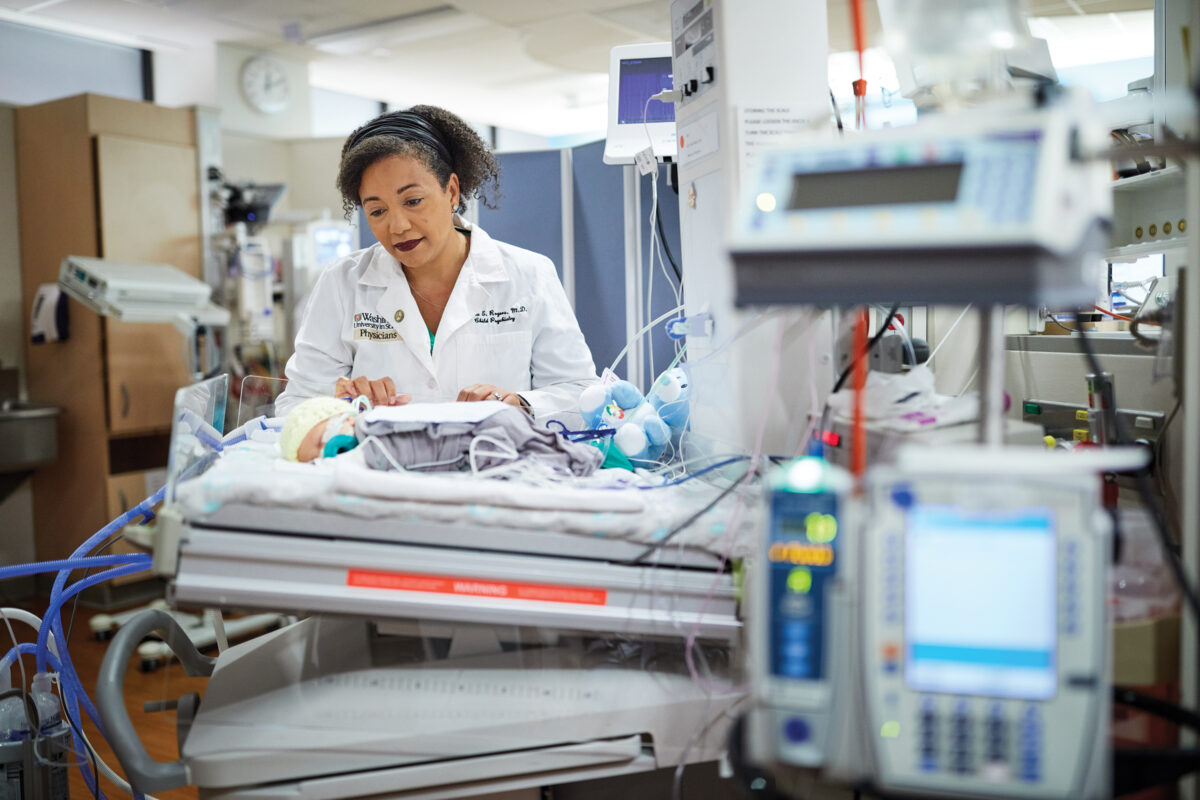 Woman doctor observing a baby in the NICU at a hospital. 